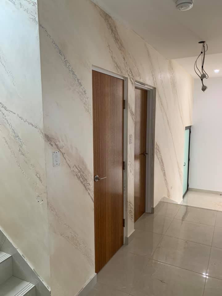 Hallway with a white marble-effect plaster wall leading to timber doors