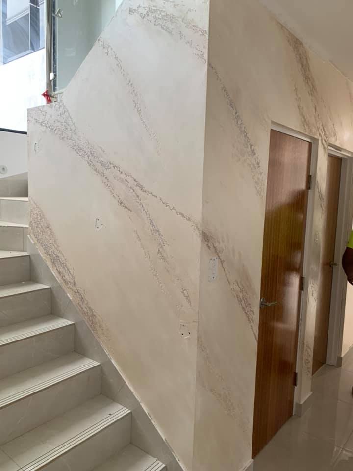 Staircase beside a white marble-effect plaster wall and timber doors