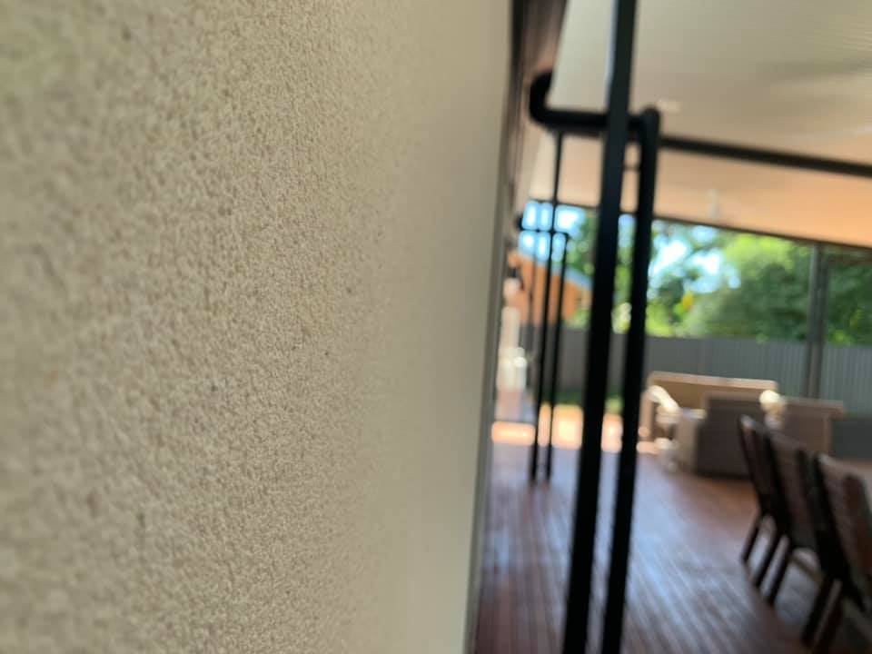 Close-up of a fine textured render wall beside a covered deck