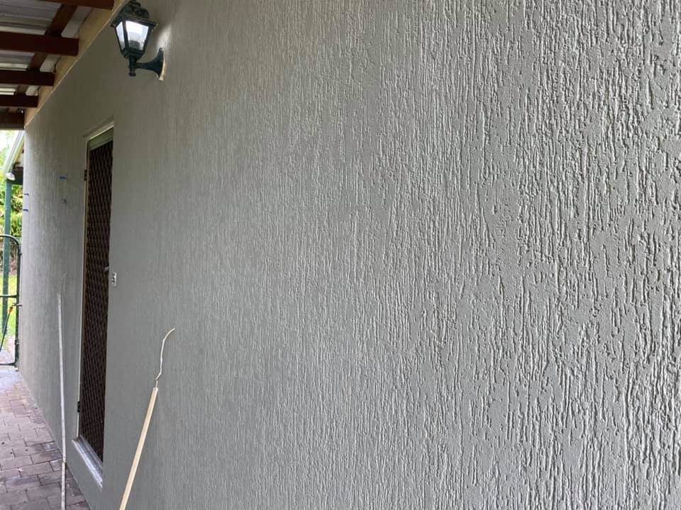 Grey exterior wall with a coarse textured render finish