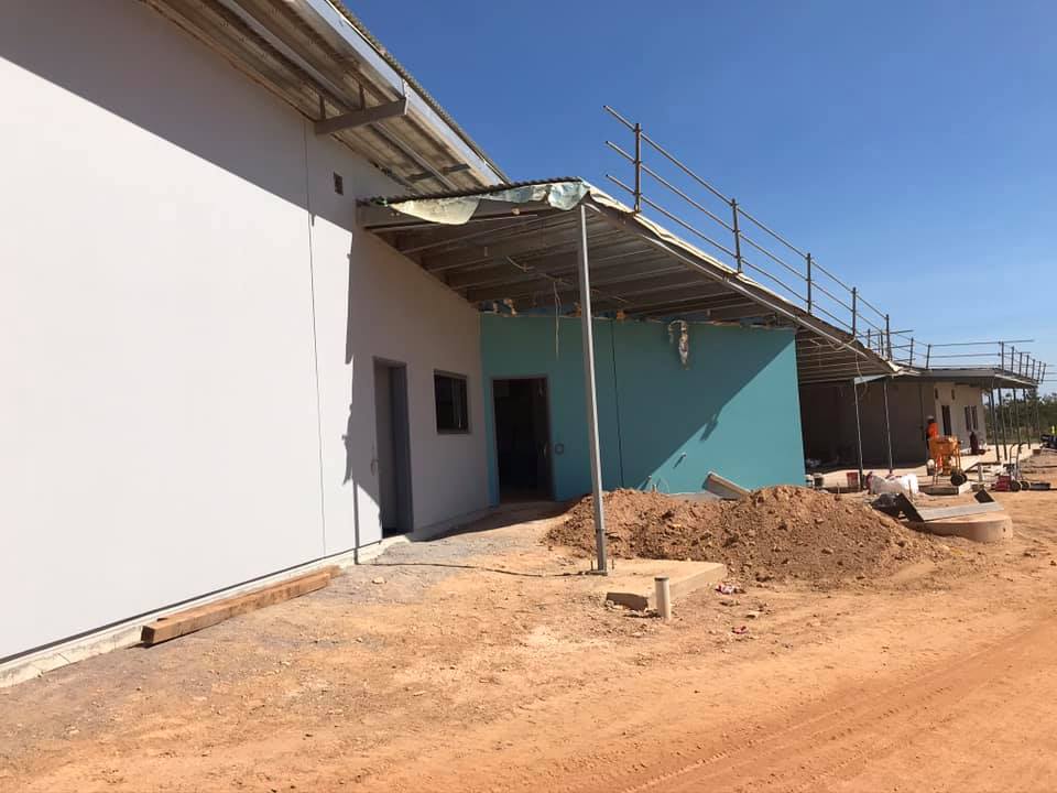 Rendered building with a teal section on a construction site