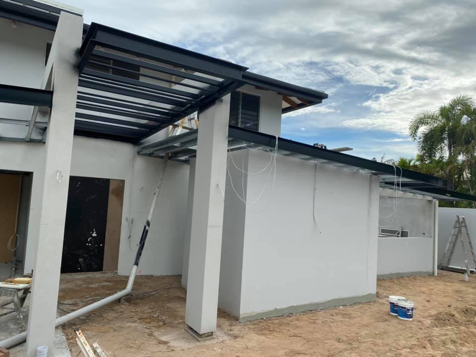 House under construction with white rendered walls and columns