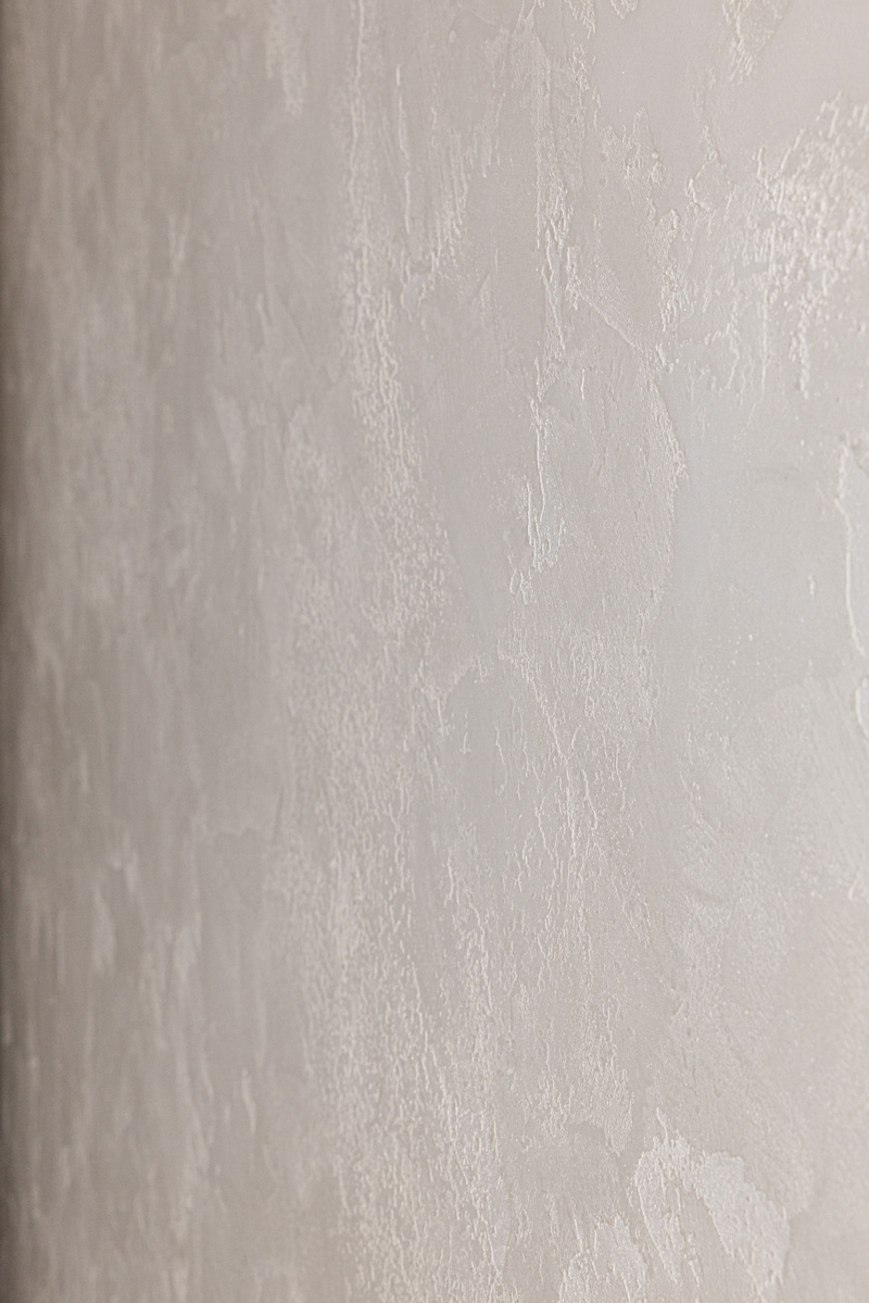 Close-up of a smooth, mottled pale plaster wall finish